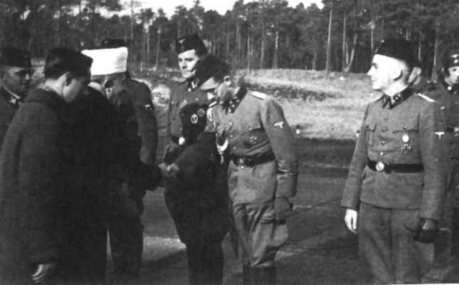 Le
grand mufti de Jrusalem (avec coiffe blanche) apporte sa
caution aux volontaires de la division musulmane  Handschar 
de la Waffen SS. Derrire lui (extrme gauche de la
photo), le Brigadefrher (gnral de brigade) Karl
Sauberzweig, commandeur de la division de mars 1943  juin
1944.